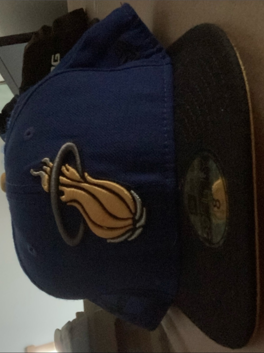 New Era Blue and Black Fitted Hat with Gold Flame Logo be